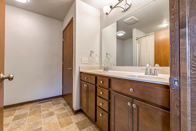 739 Pinehurst Dr, Mukwonago, WI 53149 - full bath featuring a textured wall, double vanity, and stone finish flooring