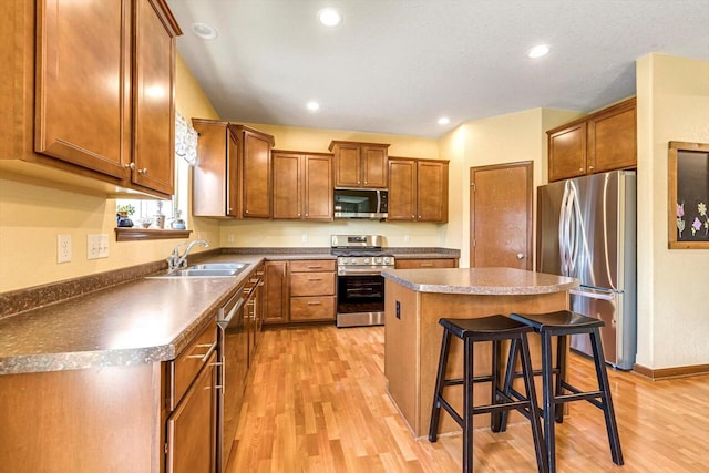 739 Pinehurst Dr, Mukwonago, WI 53149 - kitchen with appliances with stainless steel finishes, light wood-type flooring, a breakfast bar, a center island, and brown cabinetry
