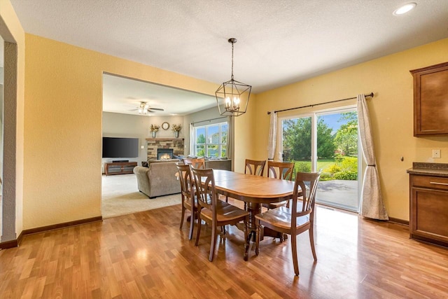 739 Pinehurst Dr, Mukwonago, WI 53149 - dining area with a fireplace, light wood-style floors, recessed lighting, and a chandelier