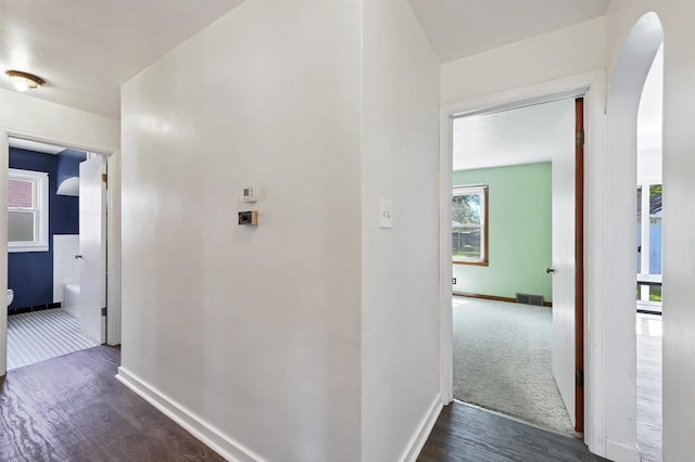 1007 14th Ave, Green Bay, WI 54304 - hall featuring arched walkways, dark wood-style floors, and dark carpet
