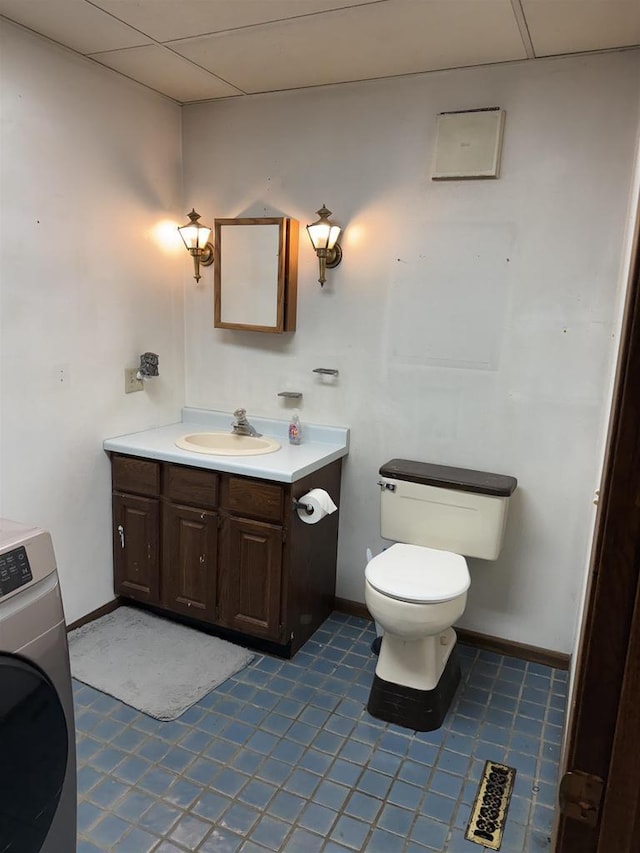 404 Prairie St, Mauston, WI 53948 - half bathroom with washer / clothes dryer, vanity, a drop ceiling, and tile patterned floors