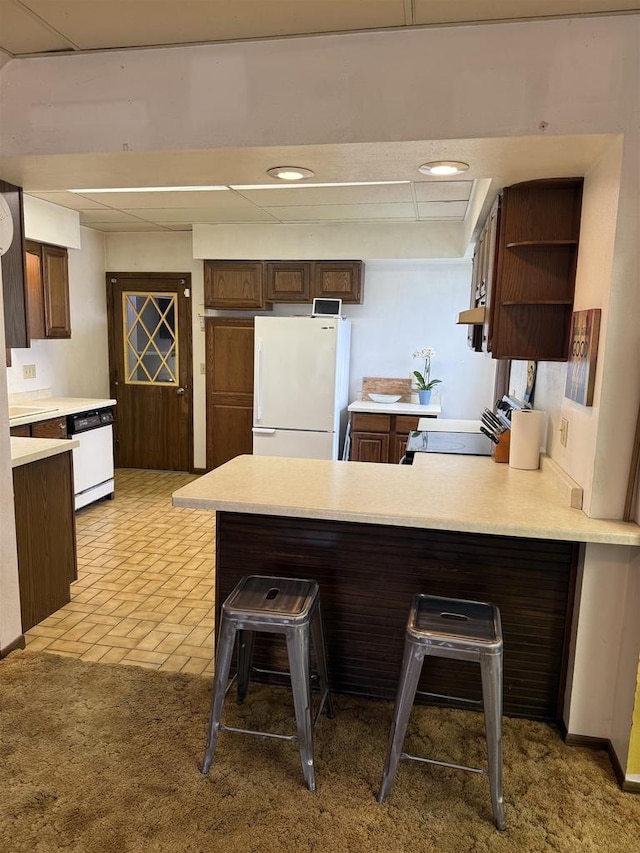 404 Prairie St, Mauston, WI 53948 - kitchen featuring white appliances, a peninsula, open shelves, light countertops, and dark brown cabinets