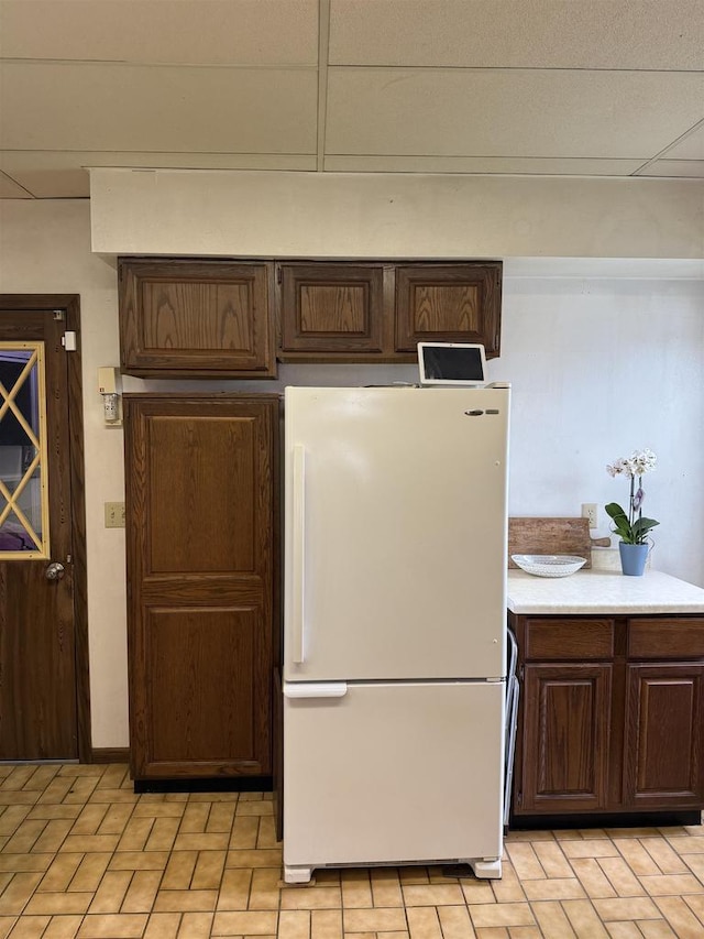 404 Prairie St, Mauston, WI 53948 - kitchen featuring freestanding refrigerator, dark brown cabinetry, and light countertops