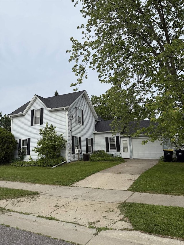 404 Prairie St, Mauston, WI 53948 - traditional-style home with concrete driveway, a front yard, an attached garage, and roof with shingles