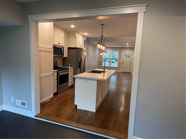 1028 Chauncey St, Eau Claire, WI 54701 - kitchen with stainless steel appliances, white cabinetry, a kitchen island with sink, light countertops, and pendant lighting