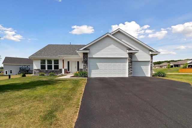 705 E Mason Dr, Edgerton, WI 53534 - view of front of home with stone siding, an attached garage, asphalt driveway, and a front yard