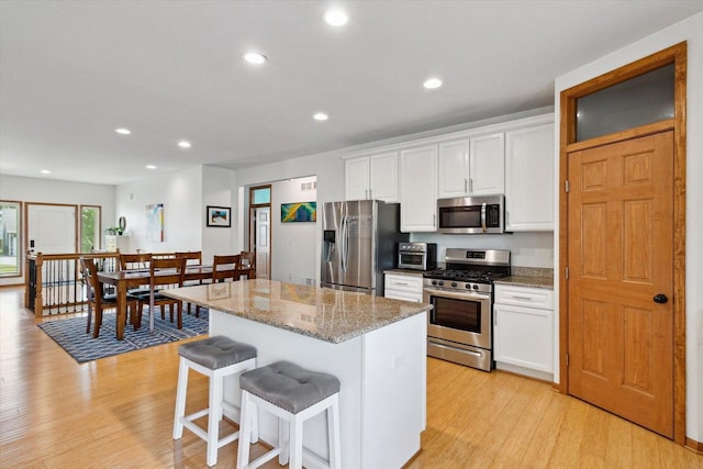 705 E Mason Dr, Edgerton, WI 53534 - kitchen featuring stainless steel appliances, light wood-type flooring, a kitchen island, white cabinets, and recessed lighting