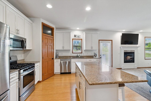 705 E Mason Dr, Edgerton, WI 53534 - kitchen with appliances with stainless steel finishes, open floor plan, a center island, white cabinetry, and recessed lighting