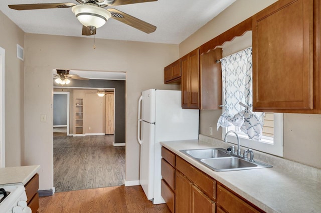 1413 Avon St, La Crosse, WI 54603 - kitchen with a ceiling fan, brown cabinets, light countertops, light wood-style flooring, and white appliances