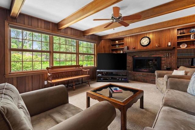 5026 Coney Weston Pl, Madison, WI 53711 - carpeted living room featuring wooden walls, beamed ceiling, a ceiling fan, built in shelves, and a brick fireplace
