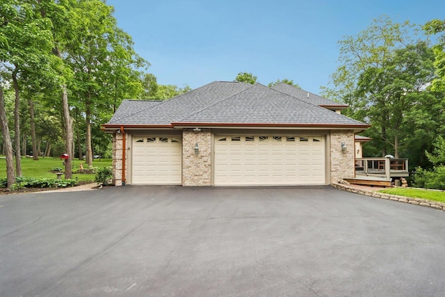 W332S9291 Red Brae Dr, Mukwonago, WI 53149 - view of home's exterior featuring asphalt driveway, a garage, a shingled roof, brick siding, and a wooden deck