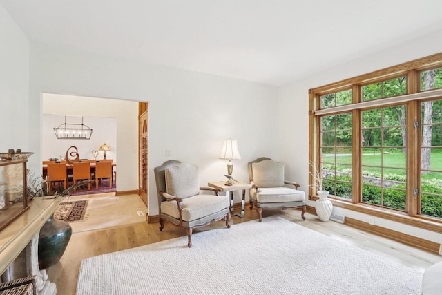 W332S9291 Red Brae Dr, Mukwonago, WI 53149 - sitting room with healthy amount of natural light, a chandelier, and wood finished floors