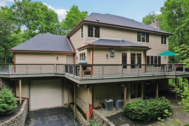W332S9291 Red Brae Dr, Mukwonago, WI 53149 - rear view of property featuring a chimney, a deck, a garage, and asphalt driveway