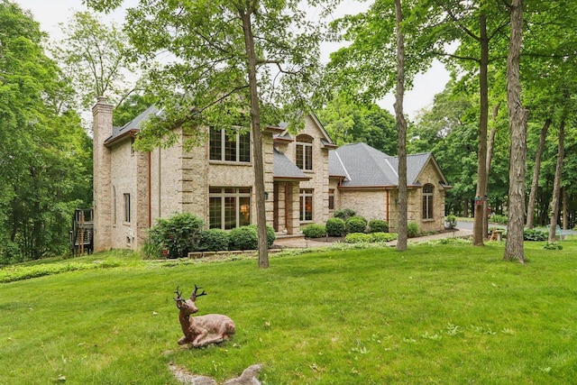 W332S9291 Red Brae Dr, Mukwonago, WI 53149 - view of front facade featuring a chimney, a front lawn, and brick siding