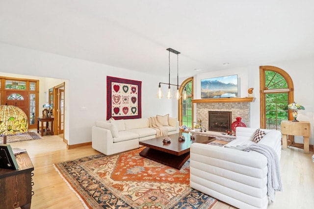 W332S9291 Red Brae Dr, Mukwonago, WI 53149 - living room with wood finished floors, a fireplace with raised hearth, and a chandelier