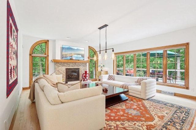 W332S9291 Red Brae Dr, Mukwonago, WI 53149 - living area featuring wood finished floors, a glass covered fireplace, and healthy amount of natural light
