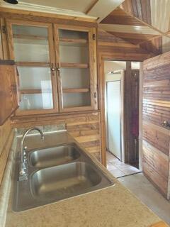 807 Charles St, La Crosse, WI 54603 - kitchen with wooden walls, glass insert cabinets, and light countertops
