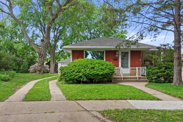 3669 S Quincy Ct, Milwaukee, WI 53207 - bungalow featuring a front yard, covered porch, a garage, and brick siding