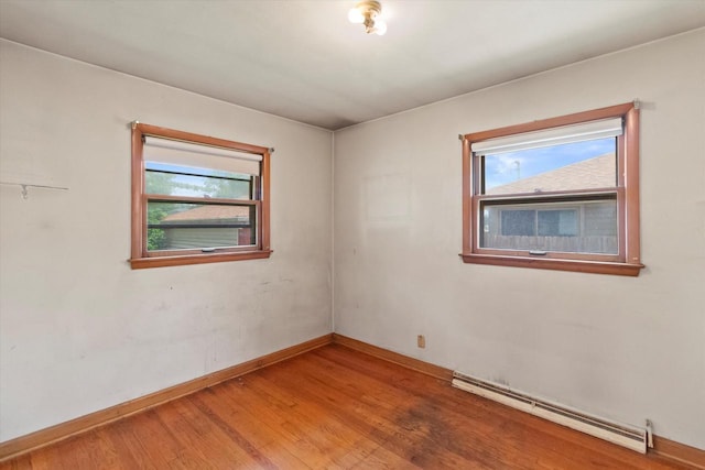 3669 S Quincy Ct, Milwaukee, WI 53207 - spare room with baseboard heating, healthy amount of natural light, and wood finished floors