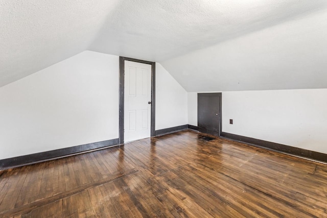 429 W Juneau St, Tomah, WI 54660 - bonus room featuring vaulted ceiling, dark wood-style flooring, and a textured ceiling