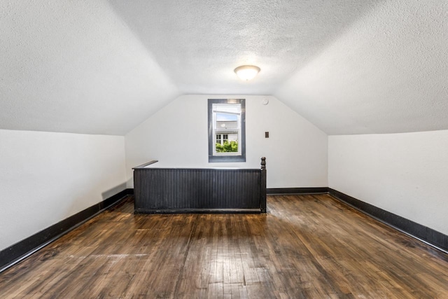 429 W Juneau St, Tomah, WI 54660 - bonus room featuring hardwood / wood-style flooring, vaulted ceiling, and a textured ceiling