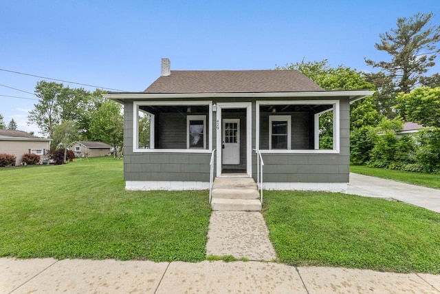 429 W Juneau St, Tomah, WI 54660 - bungalow-style home featuring a chimney, a front lawn, and a shingled roof