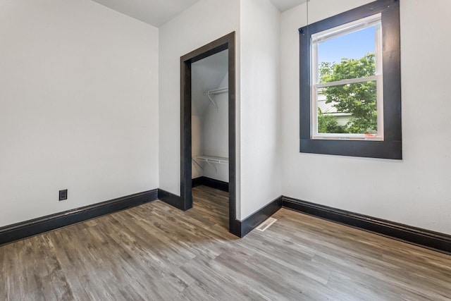 429 W Juneau St, Tomah, WI 54660 - unfurnished bedroom featuring wood finished floors, a spacious closet, and a closet