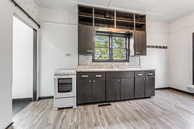 429 W Juneau St, Tomah, WI 54660 - kitchen featuring electric stove, light wood-style floors, open shelves, and backsplash