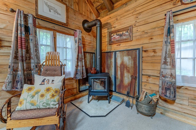 W3562 Glencoe Ave, Montello, WI 53949 - living area featuring wood walls, a wood stove, carpet, and beamed ceiling