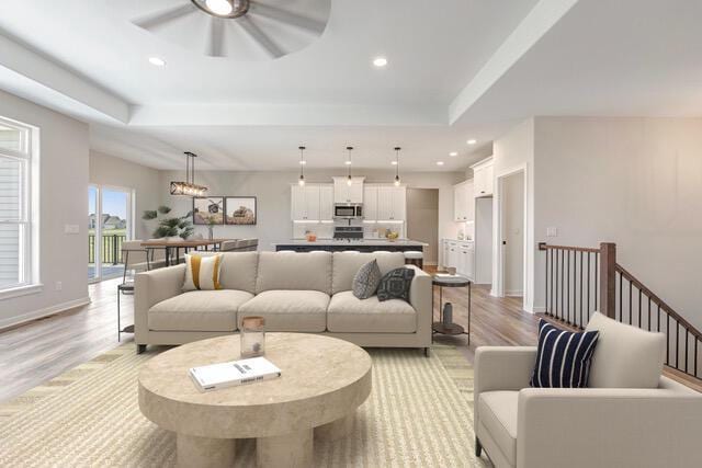 1597 Bluestem Trl, Oconomowoc, WI 53066 - living room with ceiling fan, light wood-style flooring, a tray ceiling, and recessed lighting