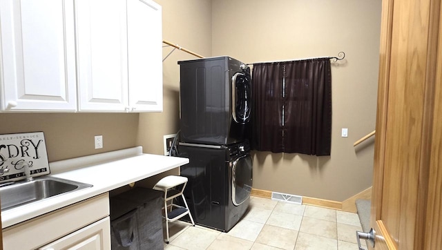 4830 Parkview Rd, Waterford, WI 53185 - laundry area with stacked washer / drying machine, cabinet space, and light tile patterned flooring