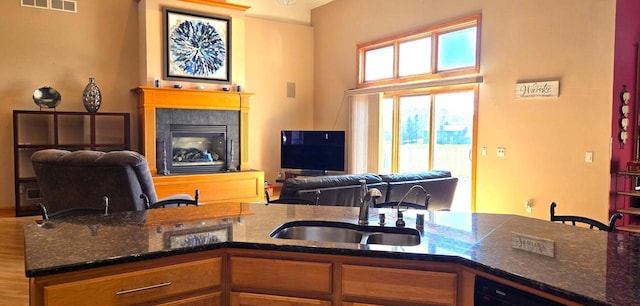 4830 Parkview Rd, Waterford, WI 53185 - kitchen with open floor plan, dark stone counters, a tiled fireplace, and dishwasher