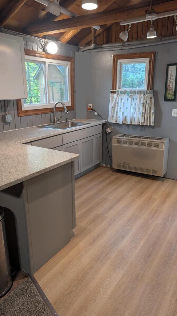 W4368 Clearwater Dr, Montello, WI 53949 - kitchen with healthy amount of natural light, light wood-type flooring, radiator, a wood ceiling with exposed beams, and light stone countertops