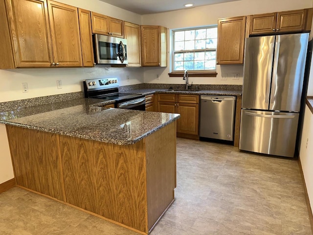 18740 Emerald Cir Unit D, Brookfield, WI 53045 - kitchen featuring stainless steel appliances, a peninsula, dark stone countertops, and brown cabinets