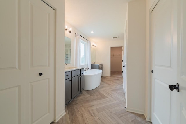 N56W24235 Torrey Pines Ln, Sussex, WI 53089 - bathroom featuring vanity, a freestanding tub, a spacious closet, and recessed lighting