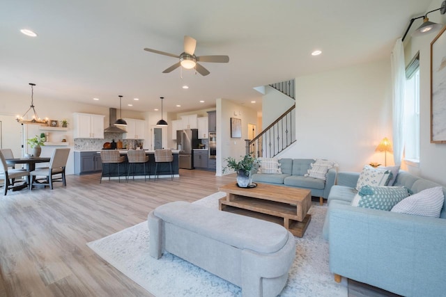 N56W24235 Torrey Pines Ln, Sussex, WI 53089 - living room featuring ceiling fan, stairway, light wood-style floors, a chandelier, and recessed lighting