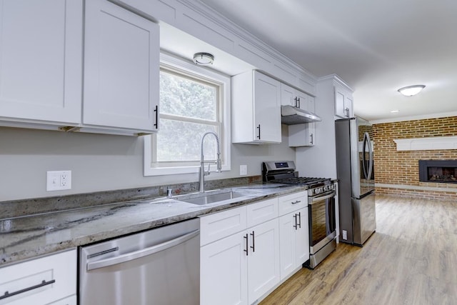 329 Meadow Ln, Deforest, WI 53532 - kitchen with stainless steel appliances, brick wall, white cabinetry, under cabinet range hood, and light stone countertops