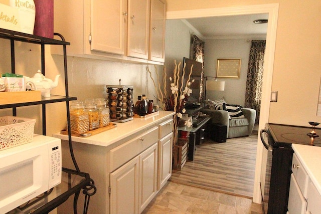 3416 S 66th St, Milwaukee, WI 53219 - kitchen with white microwave, black range with electric cooktop, and light countertops