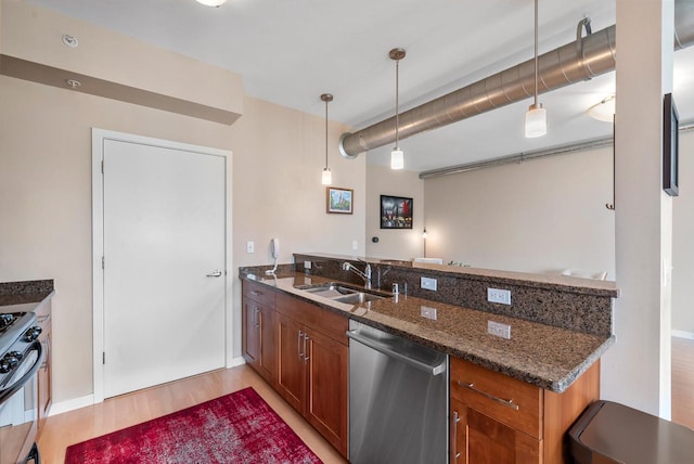 1541 N Jefferson St Unit 408, Milwaukee, WI 53202 - kitchen featuring stainless steel dishwasher, a peninsula, gas stove, and brown cabinets