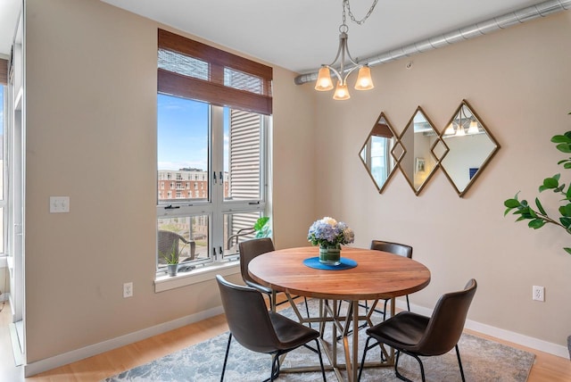1541 N Jefferson St Unit 408, Milwaukee, WI 53202 - dining area featuring healthy amount of natural light, light wood-style floors, and a chandelier