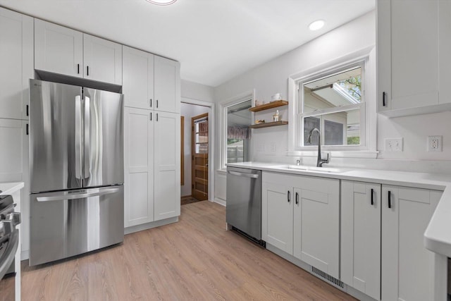 4410 N 107th St, Milwaukee, WI 53225 - kitchen featuring appliances with stainless steel finishes, light countertops, light wood finished floors, recessed lighting, and white cabinetry