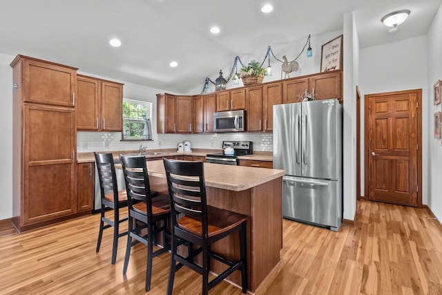 606 E Sheila Ave, Elkhorn, WI 53121 - kitchen with stainless steel appliances, light countertops, decorative backsplash, light wood-type flooring, and lofted ceiling
