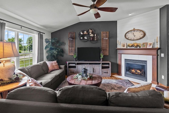 606 E Sheila Ave, Elkhorn, WI 53121 - living room featuring ceiling fan, vaulted ceiling, light wood finished floors, and a tiled fireplace