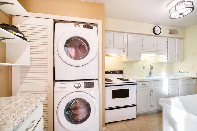 8735 N 72nd St Unit 202, Milwaukee, WI 53223 - washroom featuring stacked washer / dryer and light tile patterned floors