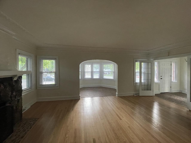 3402 N 51st Blvd, Milwaukee, WI 53216 - unfurnished living room featuring wood finished floors, a fireplace with flush hearth, arched walkways, and ornamental molding