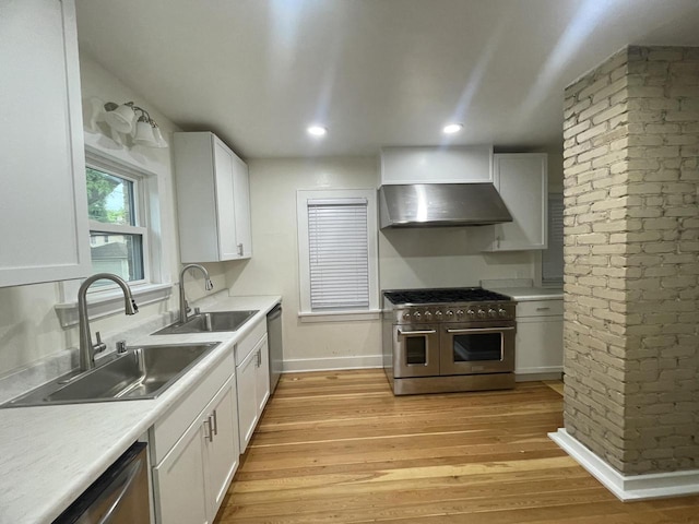 3402 N 51st Blvd, Milwaukee, WI 53216 - kitchen featuring stainless steel appliances, under cabinet range hood, light wood-style floors, white cabinets, and brick wall