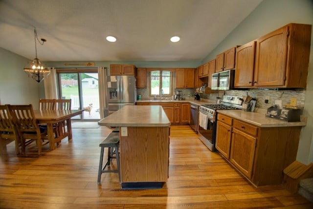 N4374 Esther Dr, Onalaska, WI 54650 - kitchen with stainless steel appliances, light countertops, lofted ceiling, a chandelier, and backsplash