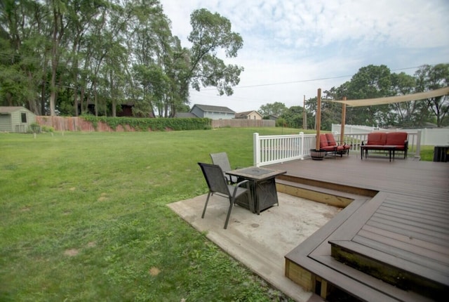 N4374 Esther Dr, Onalaska, WI 54650 - fenced yard featuring a wooden deck, a storage shed, and an outdoor living space with a fire pit