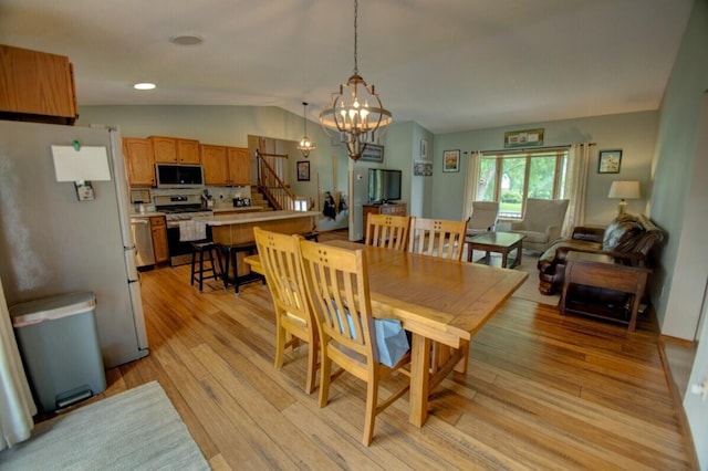 N4374 Esther Dr, Onalaska, WI 54650 - dining space featuring a chandelier, stairway, lofted ceiling, and light wood-style floors