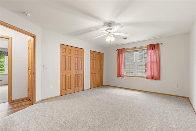 677 Wood River Ct, West Bend, WI 53095 - unfurnished bedroom featuring light colored carpet, two closets, and a ceiling fan